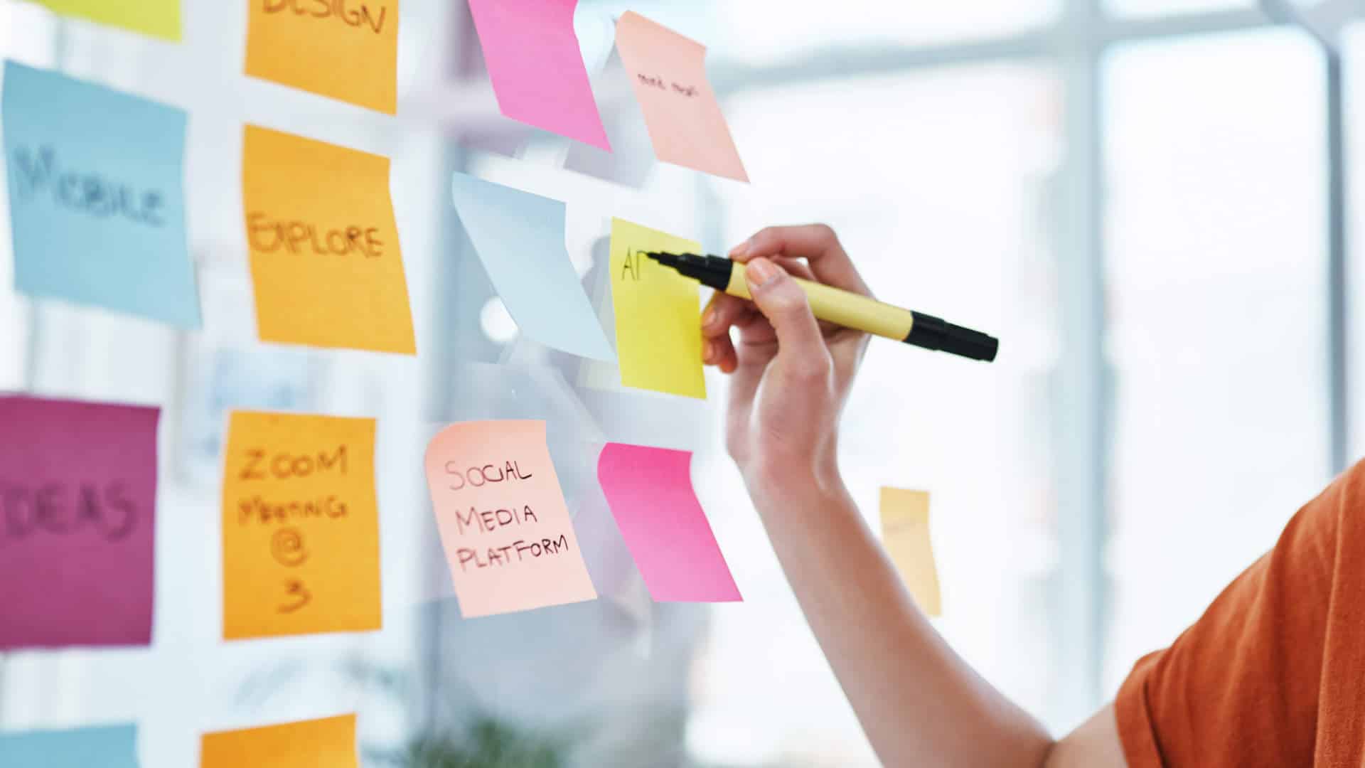 Persona escribiendo en post-it y creando una estructura de análisis